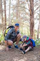 Happy father kneeling by boy tying shoelace