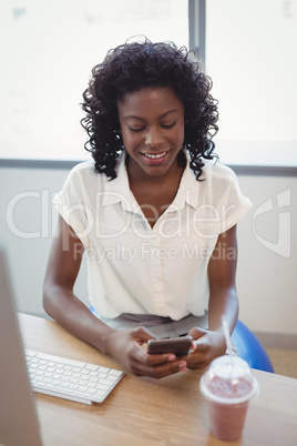 Executive using mobile phone at desk