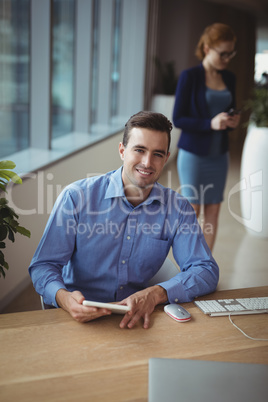 Portrait of executive using digital tablet at desk