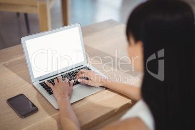 Attentive executive using laptop at desk