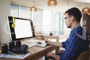 Attentive graphic designer using graphic tablet at desk