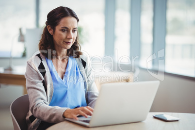 Attentive executive using laptop at desk
