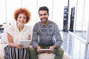 Portrait of smiling business colleagues with tablet pcs