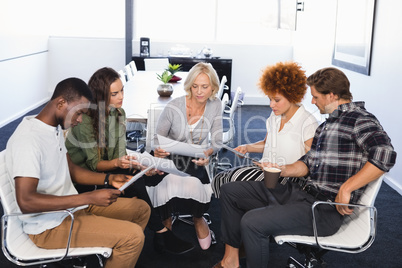 Business people discussing while sitting on chairs
