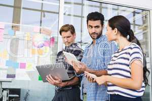 Business people discussing over tablet in office