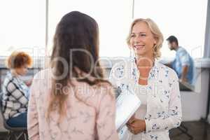 Smiling businesswoman interacting with collaeague