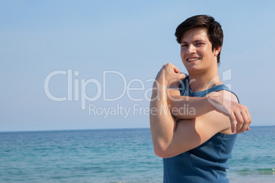 Smiling man stretching his hand on beach