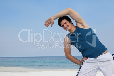 Smiling man doing warm up on beach