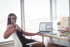Portrait of smiling businesswoman sitting at creative office