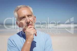 Thoughtful senior man standing at beach