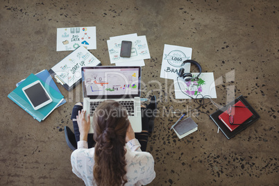 Graphic designer with laptop working on floor