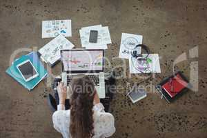 Graphic designer with laptop working on floor