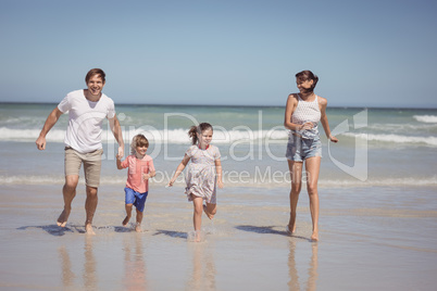 Happy family running on shore at beach