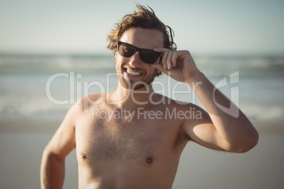 Portrait of shirtless man wearing sunglasses at beach