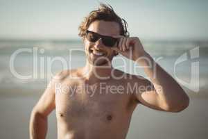 Portrait of shirtless man wearing sunglasses at beach