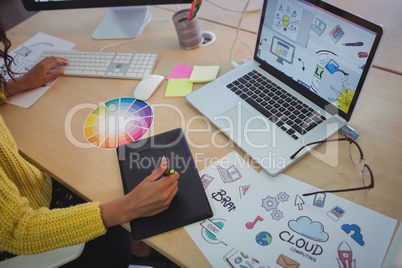 Female editor using digitizer on desk in office