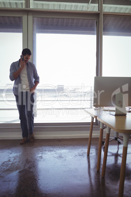 Graphic designer talking on mobile phone in office