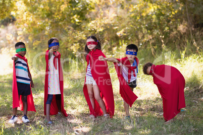 Friends enjoying while wearing superhero costume at campsite