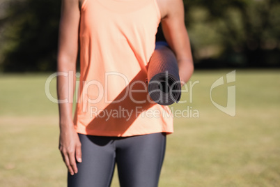 Midsection of woman holding exercise mat