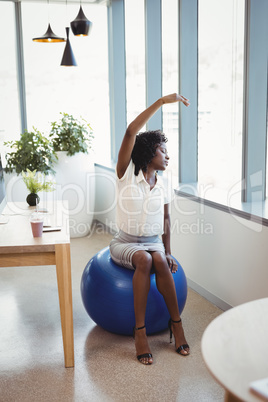 Executive performing stretching exercise on fitness ball