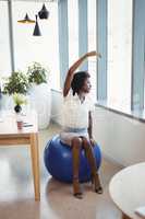 Executive performing stretching exercise on fitness ball