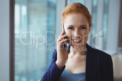 Portrait of smiling executive talking on mobile phone