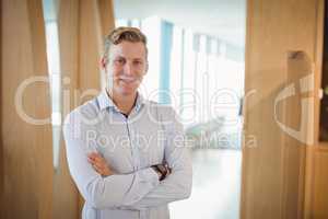 Portrait of smiling executive standing with arms crossed