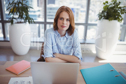 Portrait of confident executive sitting at desk