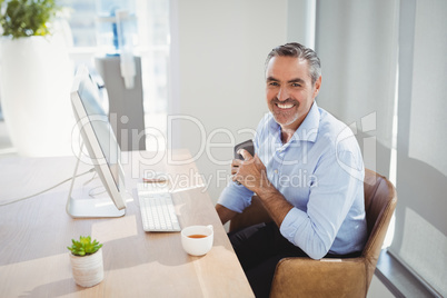 Portrait of smiling executive sitting at desk