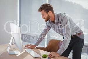 Attentive executive working on personal computer at desk