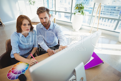 Attentive executives working over personal computer at desk