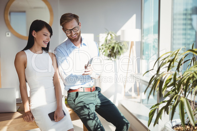 Happy executives using mobile phone at desk