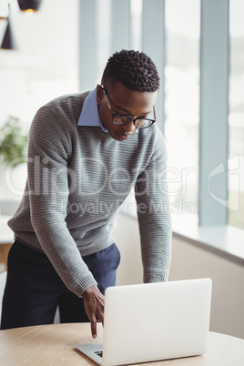 Attentive executive using laptop at desk