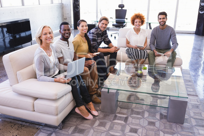 Portrait of smiling colleagues sitting on sofa