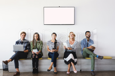 Portrait of smiling business people sitting on seat