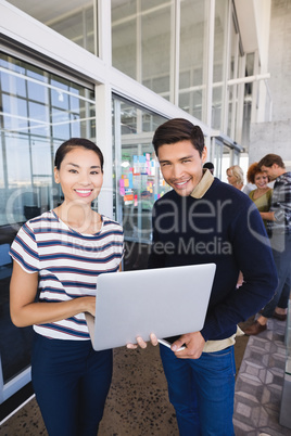 Portrait of smiling business people with laptop computer