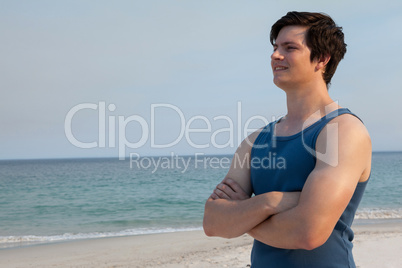 Man standing on beach with arms crossed