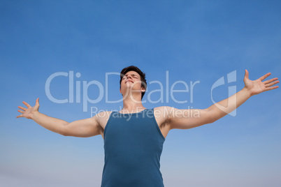 Man standing at beach with arms outstretched