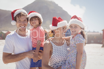 Smiling family wearing Santa hat