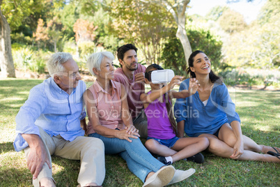 Girl using vr headset while sitting with her family