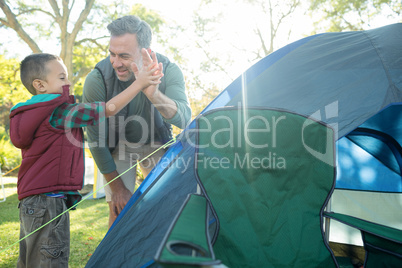 Father and son giving a high five after setting up the tent