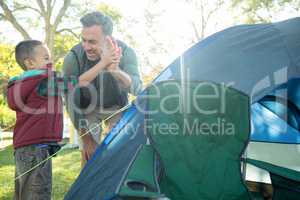 Father and son giving a high five after setting up the tent