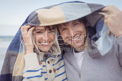 Portrait of smiling couple with blanket during winter