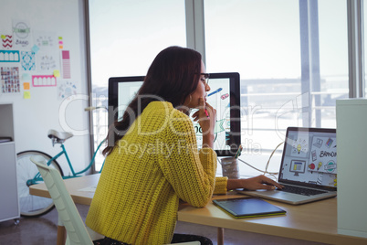 Female photo editor using laptop in creative office