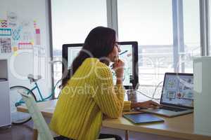 Female photo editor using laptop in creative office