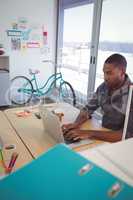 Businessman using laptop on desk in office