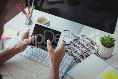 Businessman using digital tablet at creative office desk