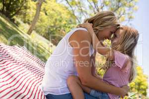 Happy mother embracing her daughter in park