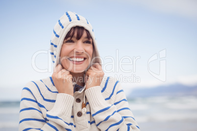Smiling woman wearing hooded sweater during winter
