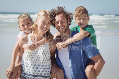 Portrait of happy family piggybacking at beach